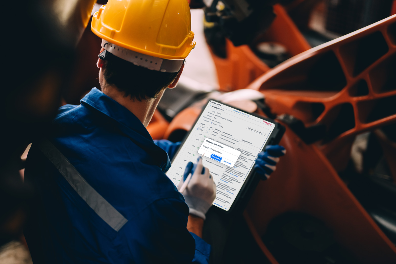 Techniker mit Tablet prüft SAP-gestützte Wartungsdaten in der Produktion