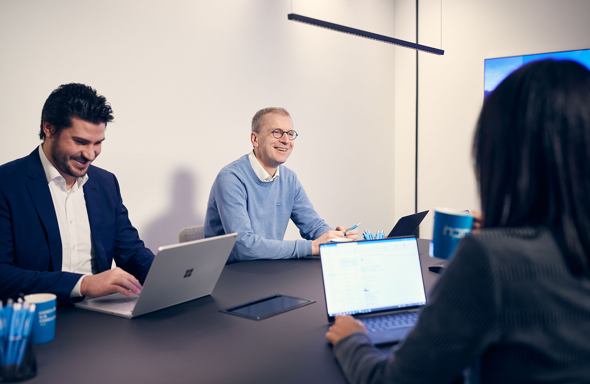 Mehre Mitarbeiter von HPC sitzen an einem Tisch in einem Meeting